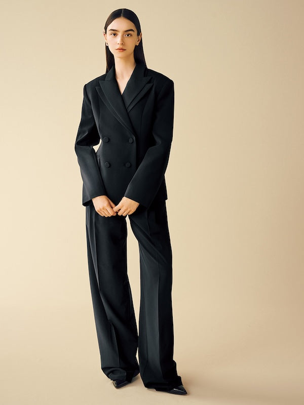 Model is wearing a black jacket and matching pants.