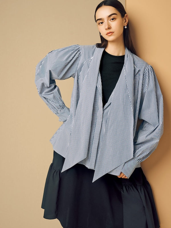 Model is wearing a black skirt and a striped shirt over a black top.