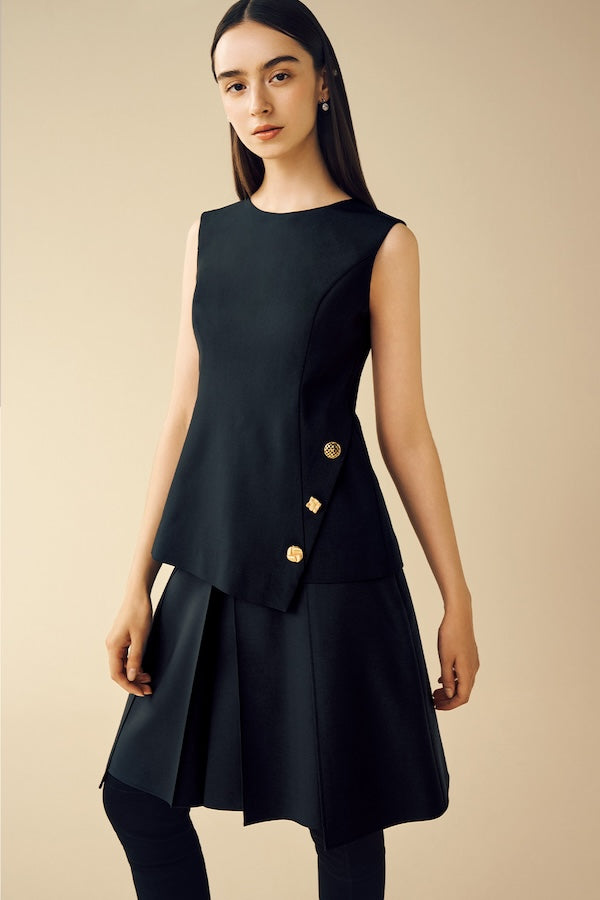 Model is wearing a black top and a skirt.