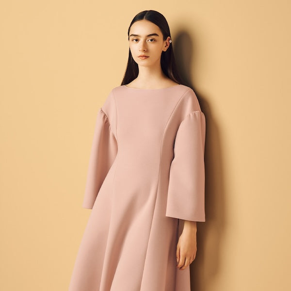 Model is wearing a pink dress.