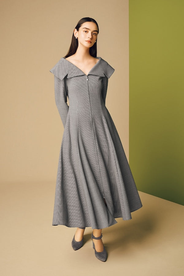 Model is wearing a grey dress and heels.