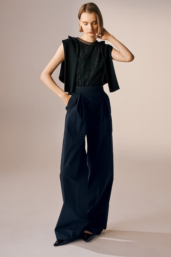 Model is wearing a black lace top with wide-leg pants.