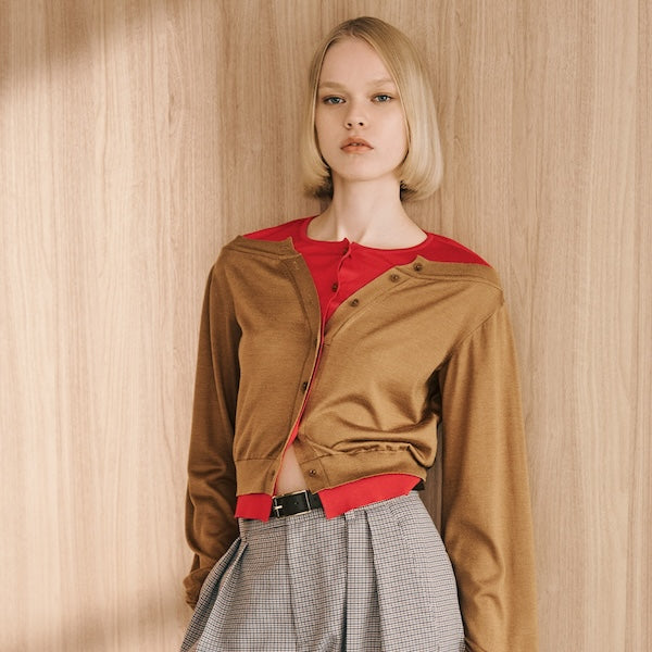 The model is wearing a brown top and plaid bottoms.